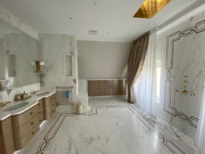 master bathroom flooring in calacatta gold with inlay